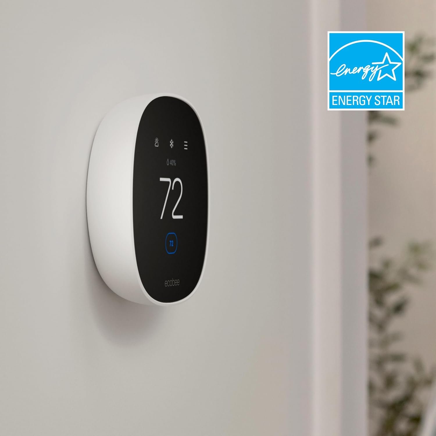 The Ecobee smart thermostat mounted on a wall, shown next to the official blue Energy Star logo, indicating its energy efficiency.