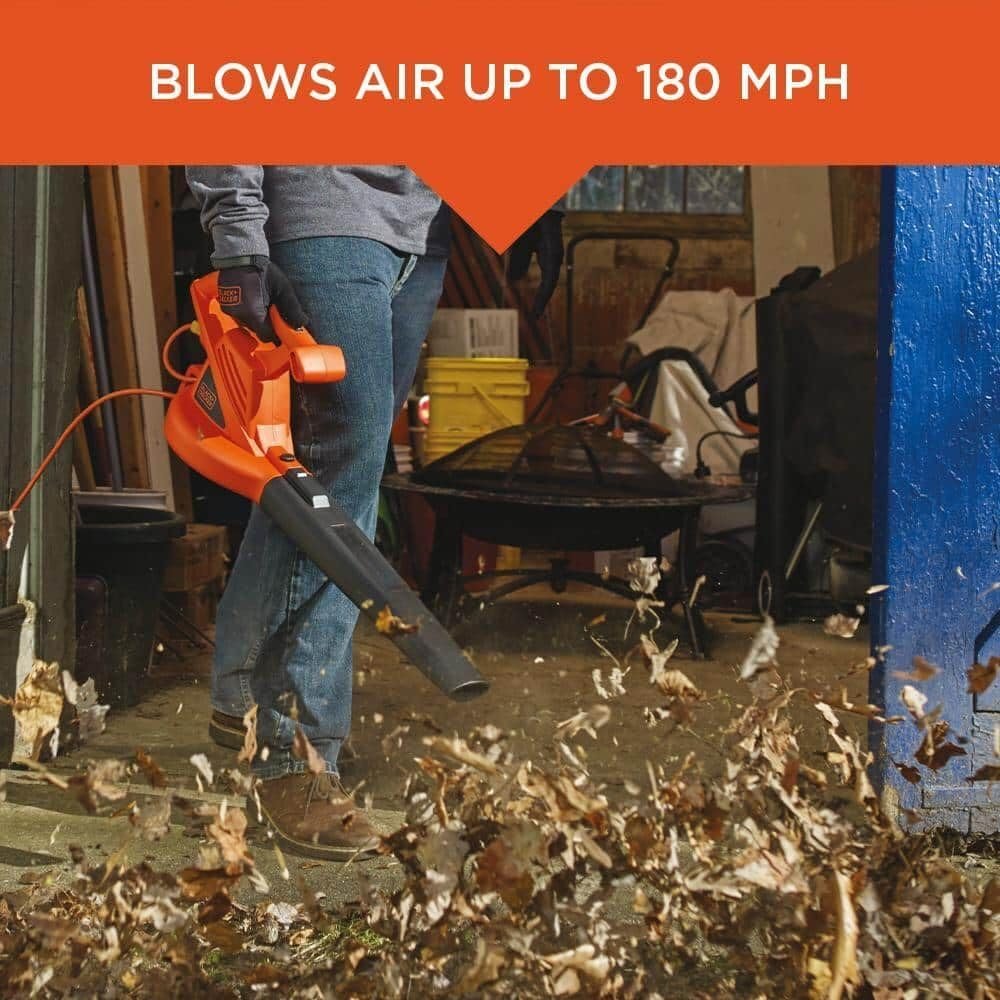 A person using the BLACK+DECKER leaf blower to clear dry leaves from a garage floor, with a text overlay "BLOWS AIR UP TO 180 MPH".