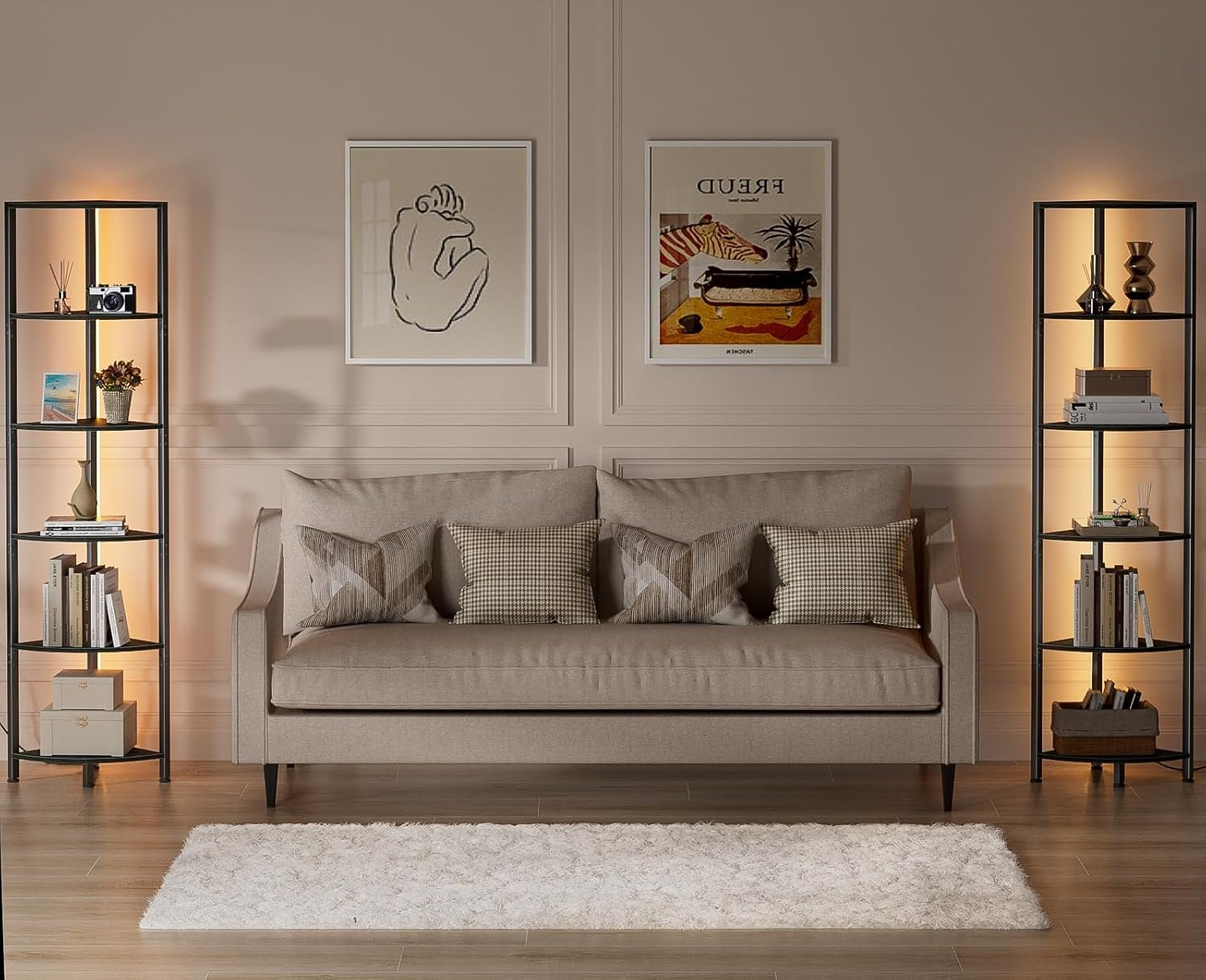 A living room setup showing two tall, black 5-shelf bookcases with warm LED lighting flanking a beige sofa.